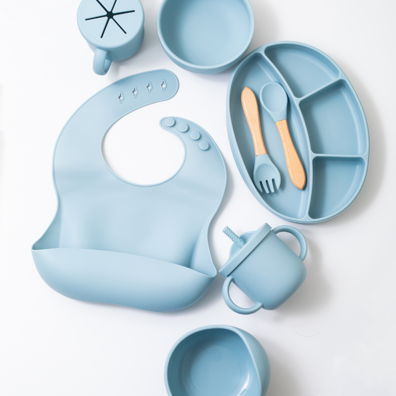 Silicon baby feeding dinner set having weaning bowl round bowl bib sectioned plate spoon sippy cup snack cup and fork in blue color