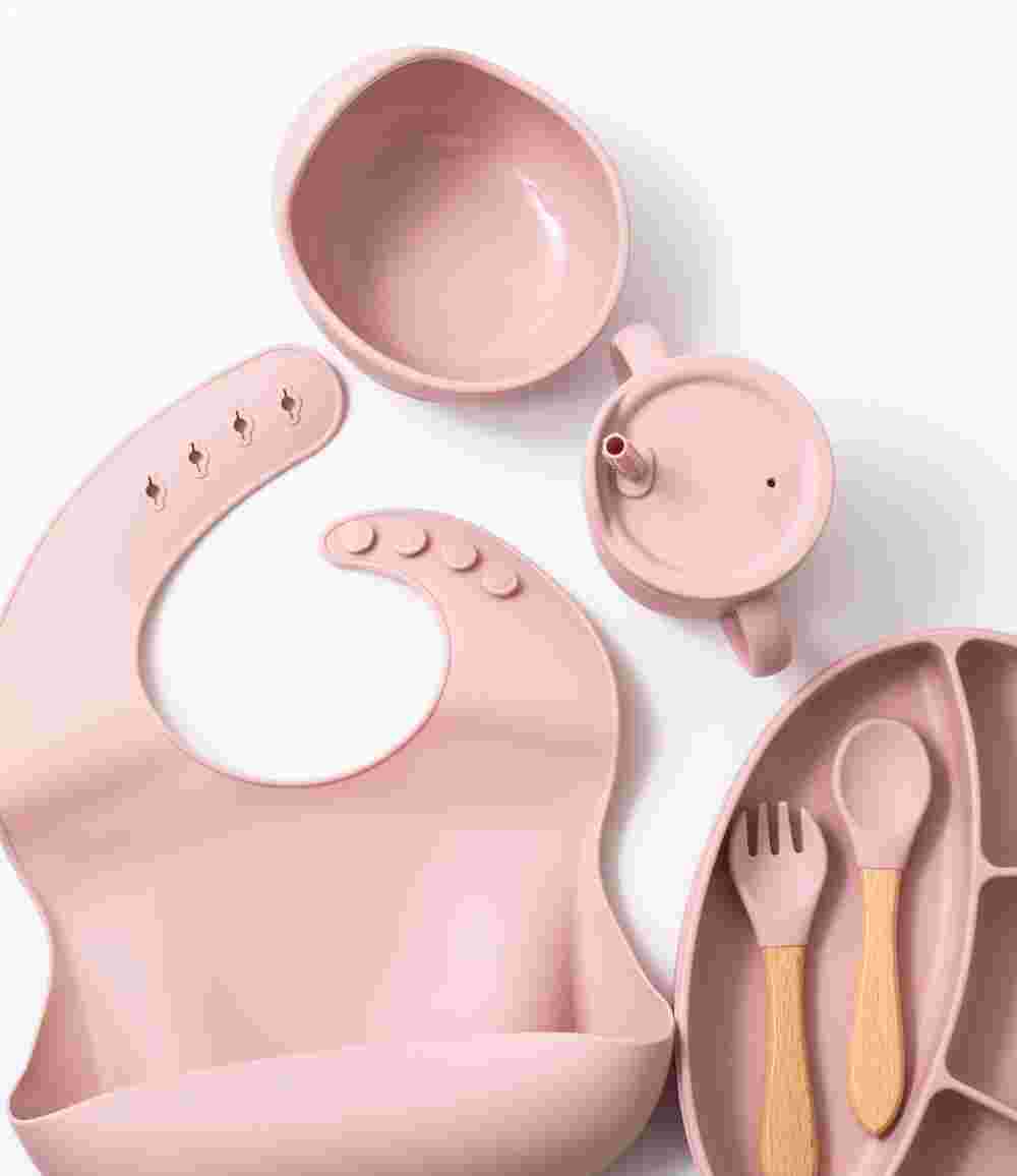 Silicon baby feeding dinner set having weaning bowl bib sectioned plate spoon sippy cup and fork in pink color
