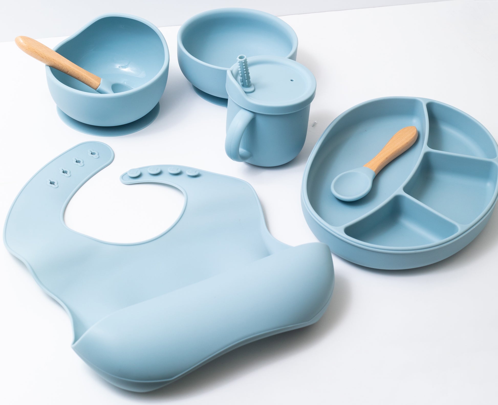 Silicon baby feeding dinner set having weaning bowl round bowl bib sectioned plate spoon sippy cup and fork in blue color