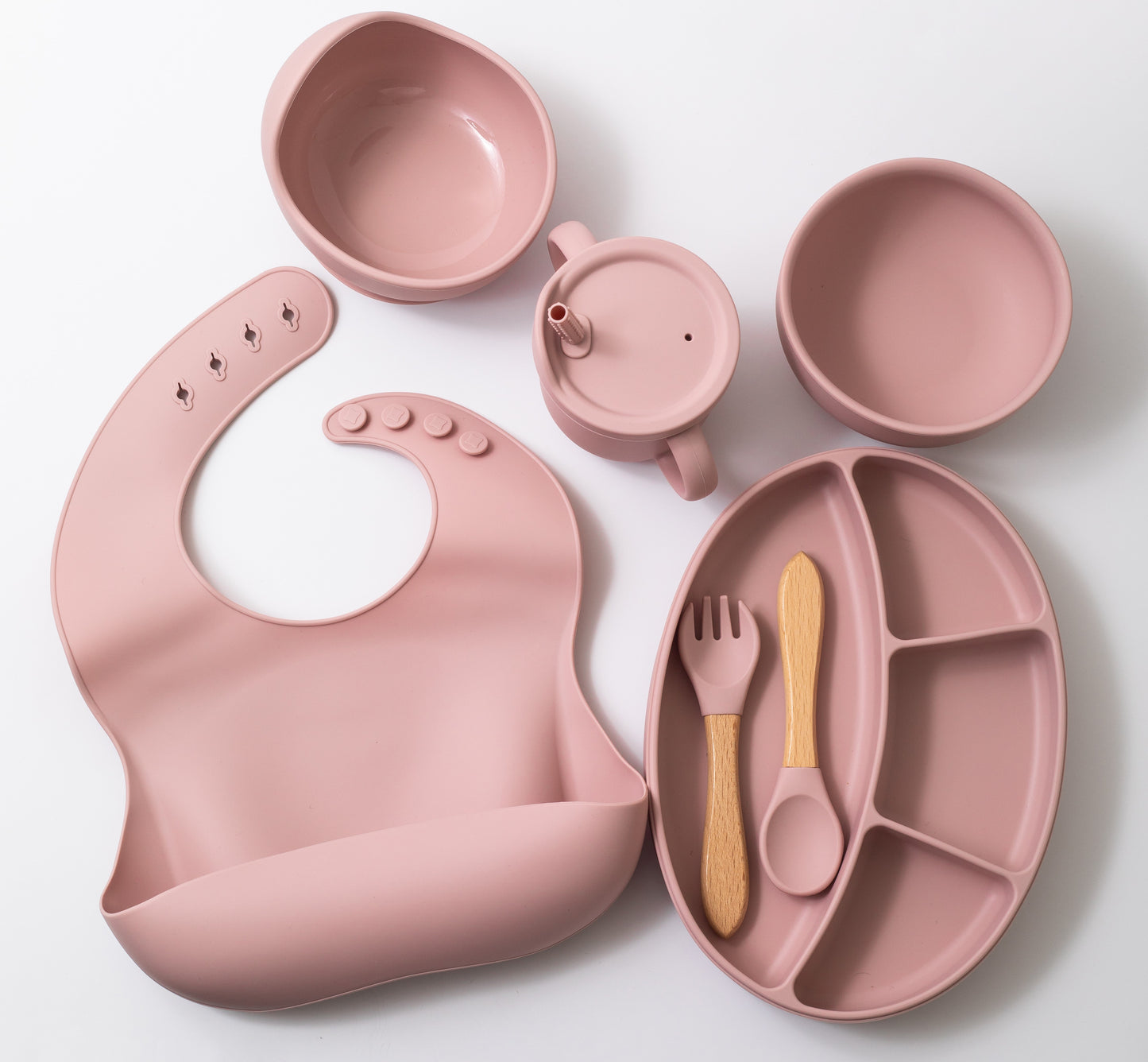 Silicon baby feeding dinner set having weaning bowl round bowl bib sectioned plate spoon sippy cup and fork in pink color