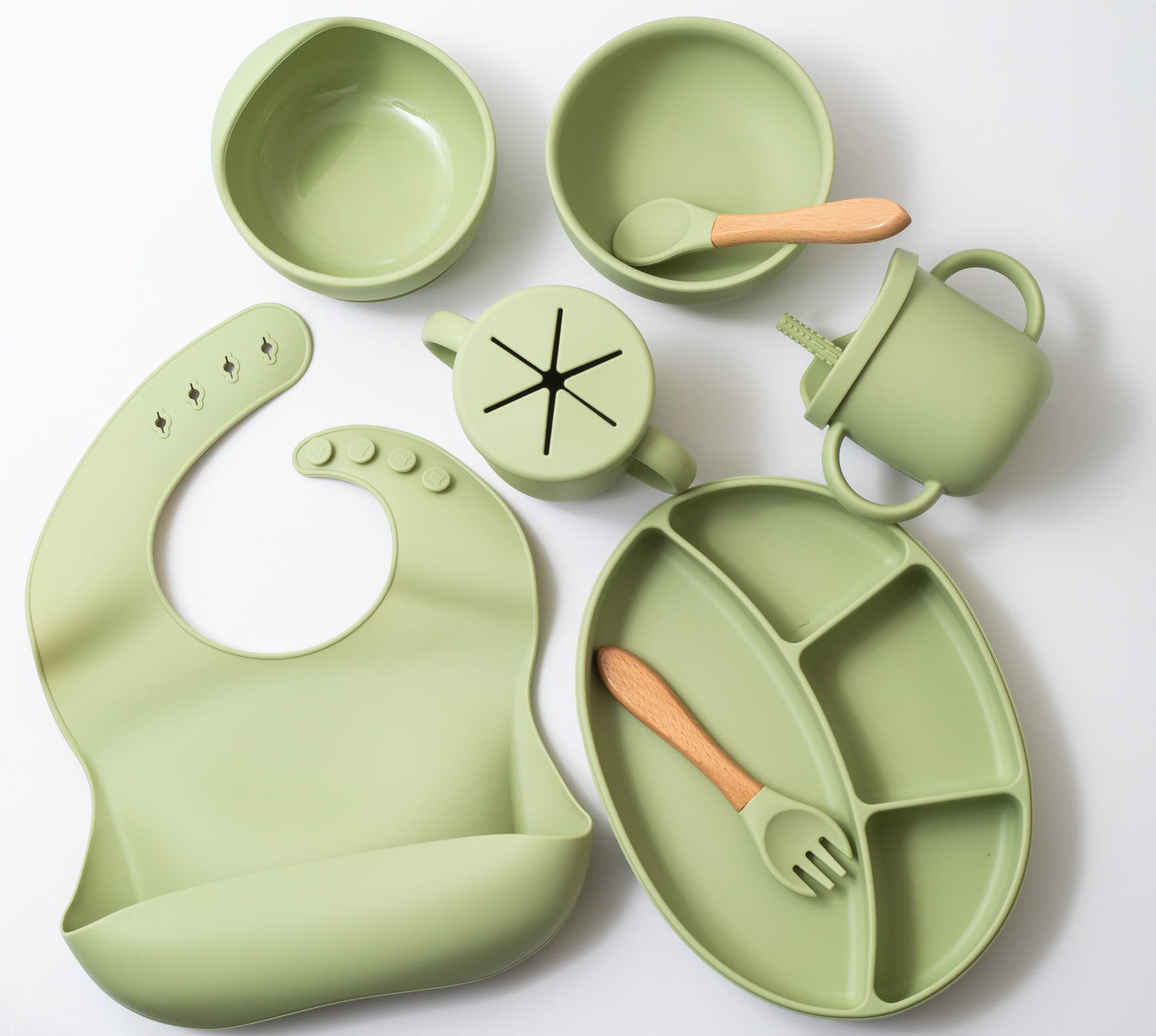 Silicon baby feeding dinner set having weaning bowl round bowl bib sectioned plate spoon sippy cup snack cup and fork in green color