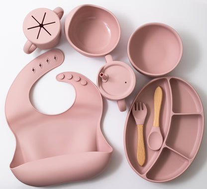 Silicon baby feeding dinner set having weaning bowl round bowl bib sectioned plate spoon sippy cup snack cup and fork in pink color