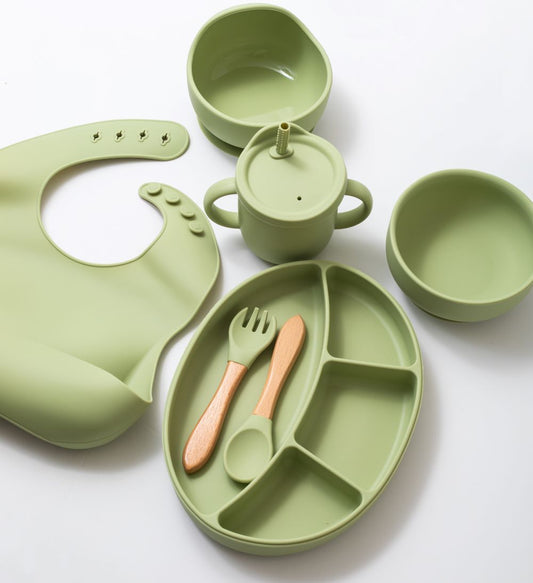 Silicon baby feeding dinner set having weaning bowl round bowl bib sectioned plate spoon sippy cup and fork in green color